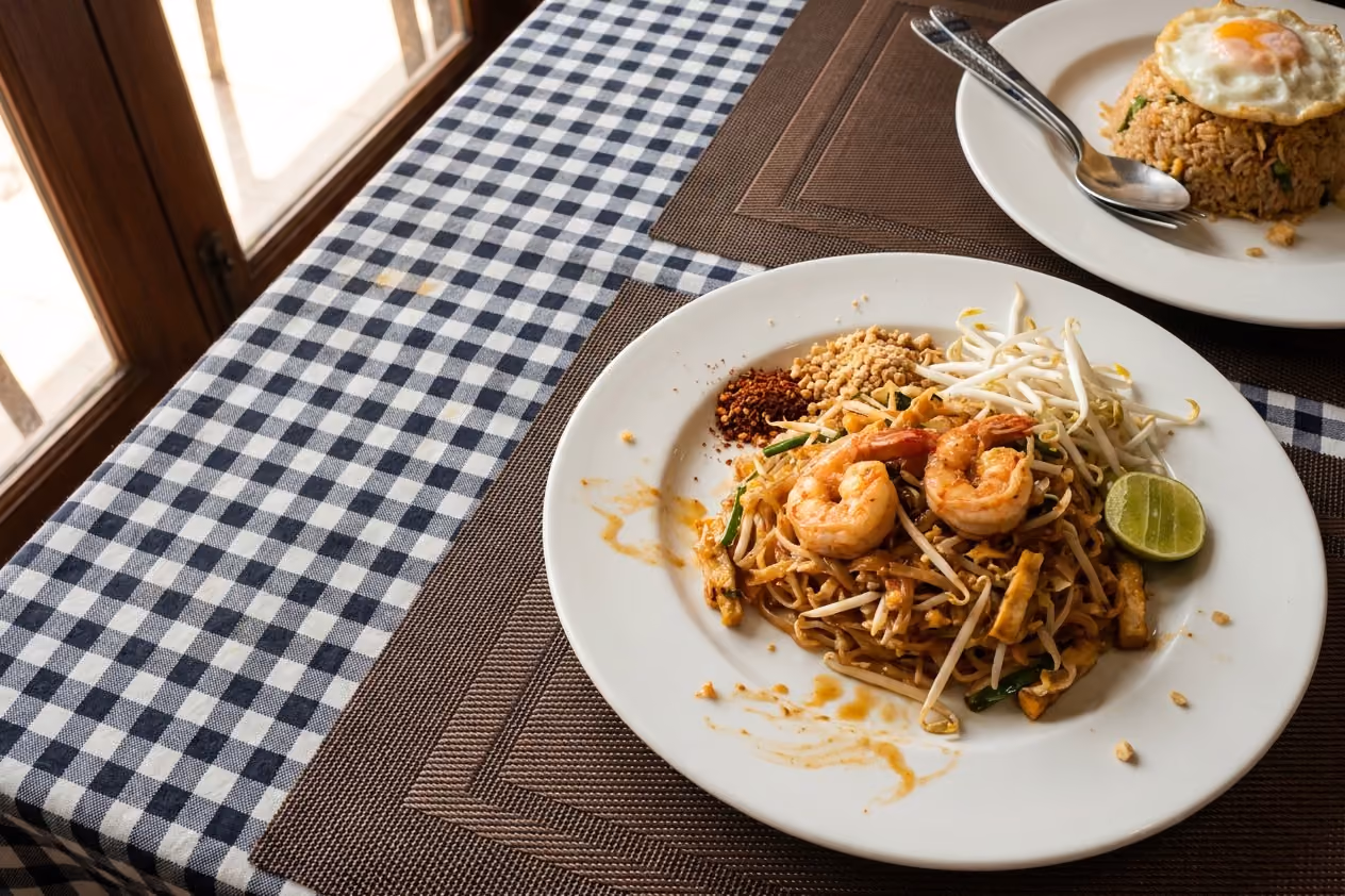ผัดไทยกุ้งกับข้าวผัดบนโต๊ะผ้าลายตาราง